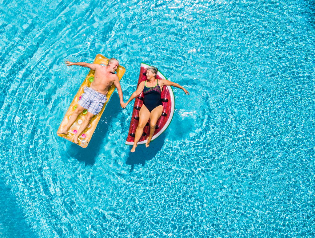 senior couple floating in pool