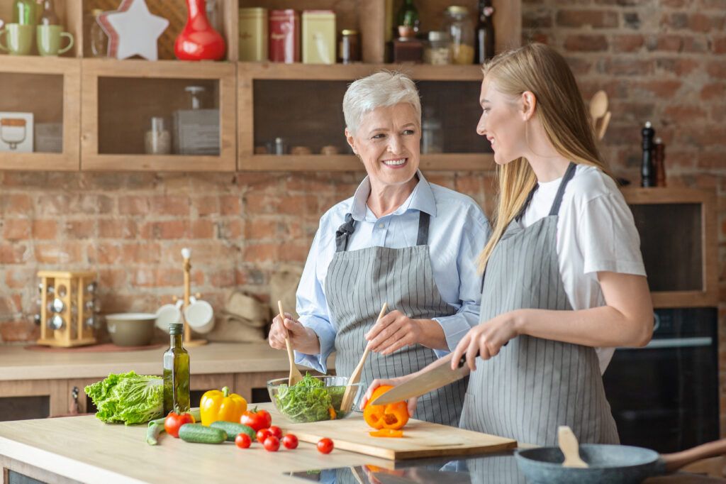 senior and caregiver preparing health meal