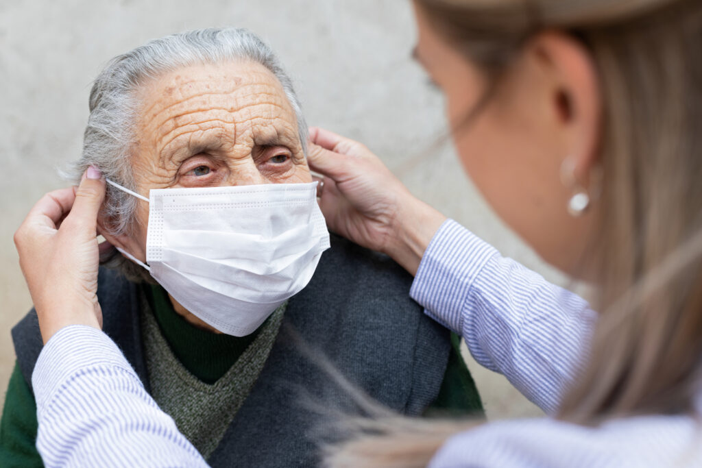 hospice nurse putting mask on senior