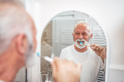 senior man brushing teeth