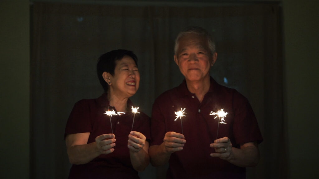 senior couple celebrating christmas in july with sparklers