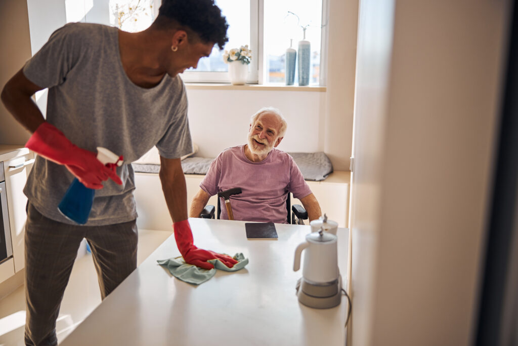 in home caregiver cleaning for senior man