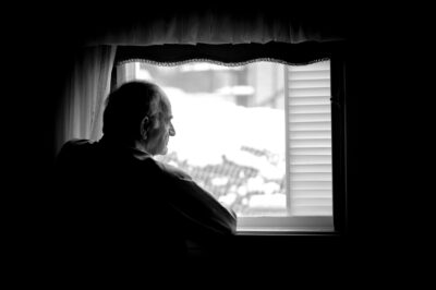 senior man alone in window