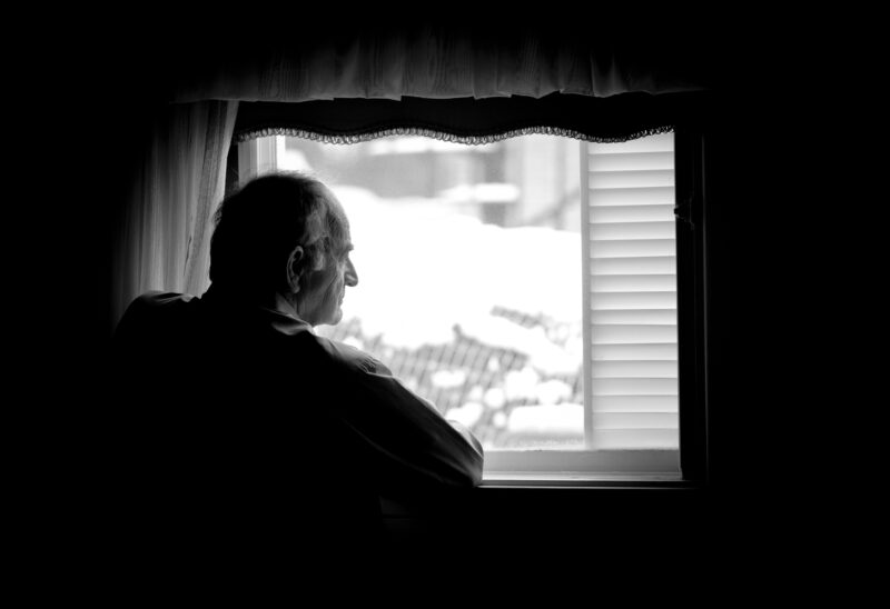 senior man alone in window