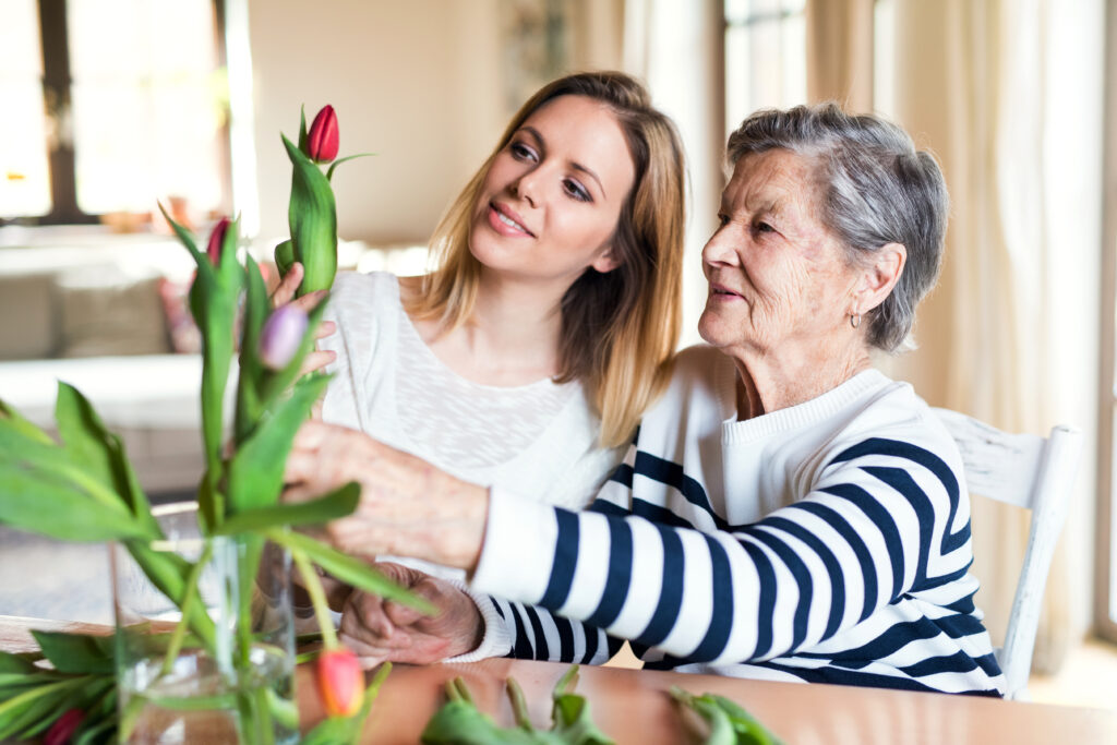 caregiver with senior and flowers