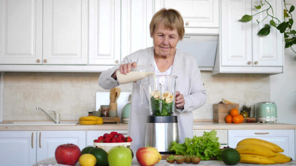 senior woman preparing plant based smoothie