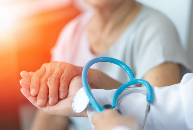 elderly person holding hand of doctor nurse