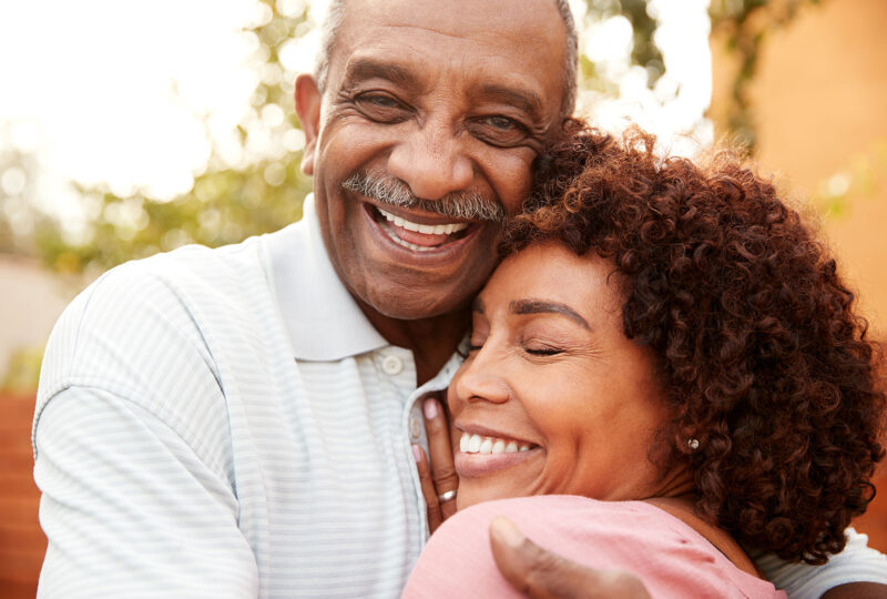 older smiling and hugging man and woman