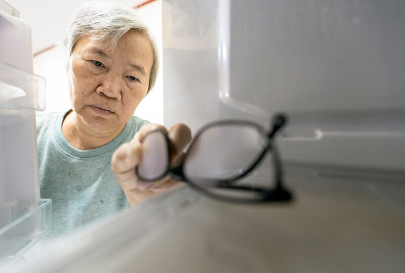person getting glasses out of refrigerator