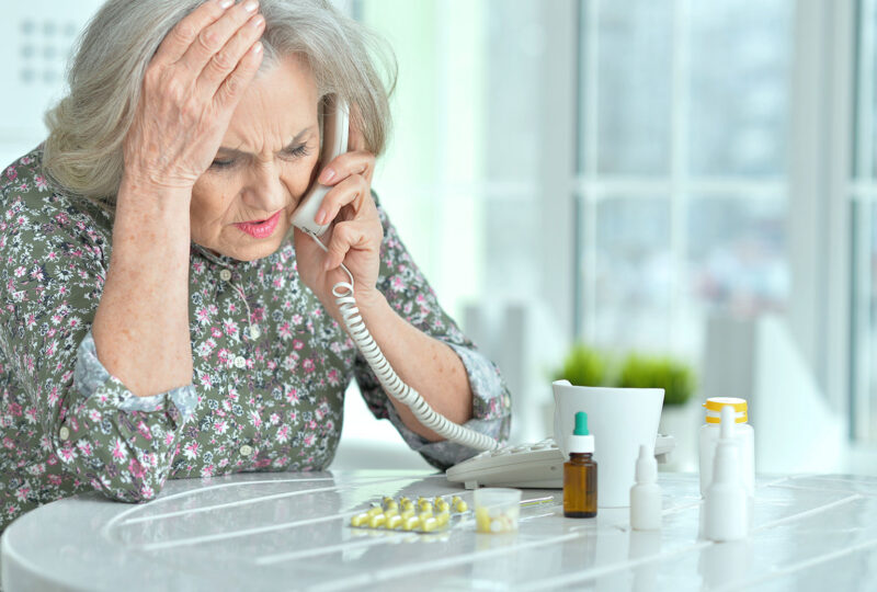confused senior woman on phone with medication