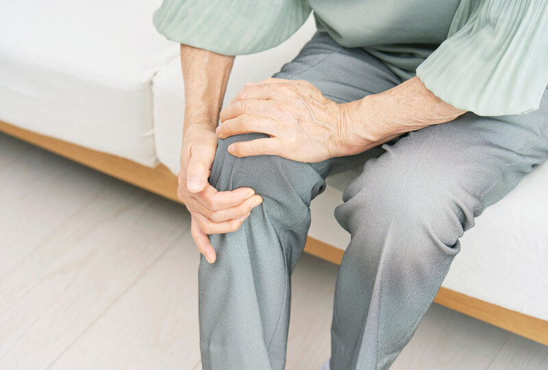 person holding their knee as if in pain