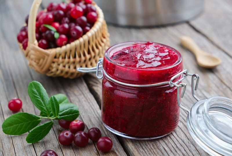 basket of cranberries and a jar of cranberry jam