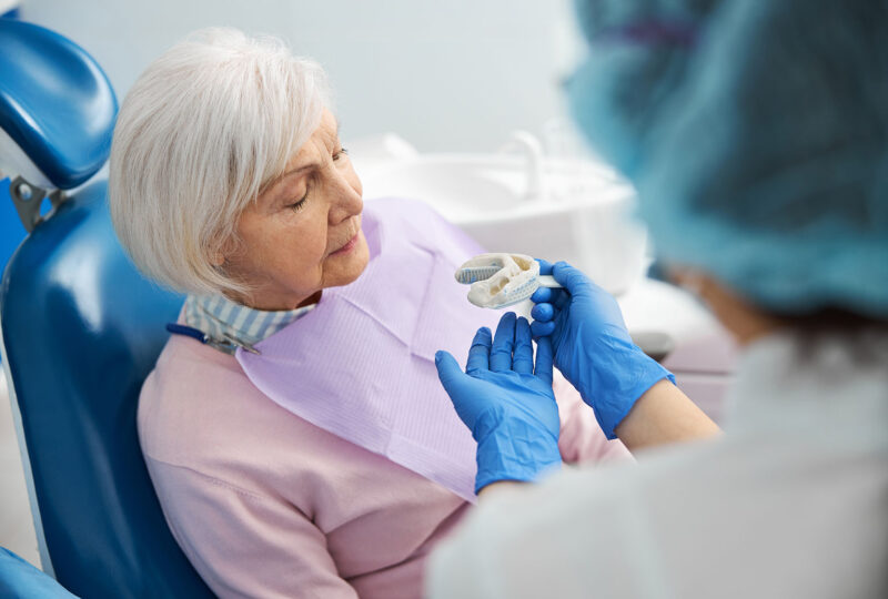senior woman in dentist chair getting fitted for dentures