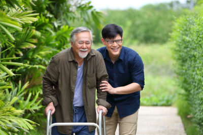 older man with walker outside with son