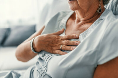 older woman with hand on chest
