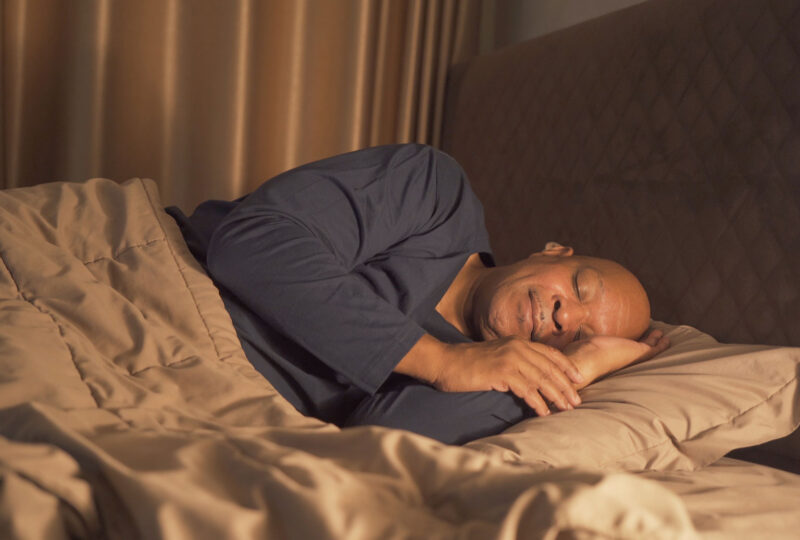man sleeping happily in bed