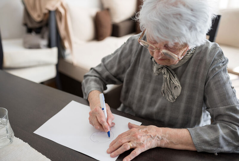 senior woman drawing on a piece of paper