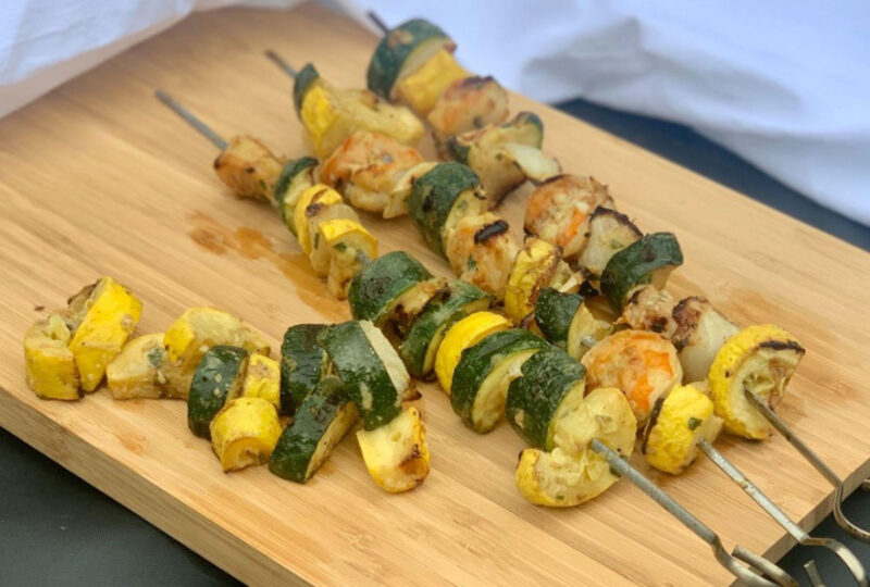 shrimp and veggie kebabs on a cutting board