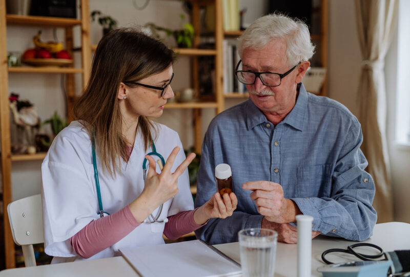 doctor speaking with senior man about prescription