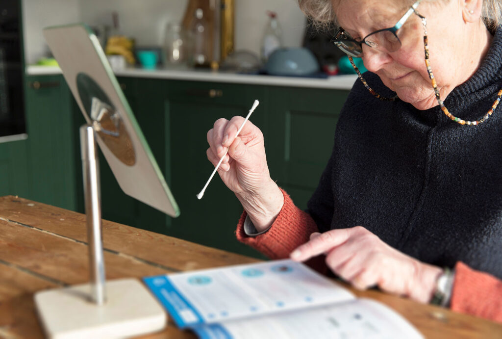 woman looking at instructions for at-home covid test