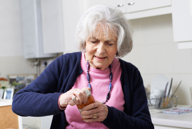 older woman trying to open a jar