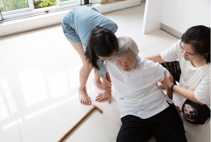 two people helping an older person off the floor
