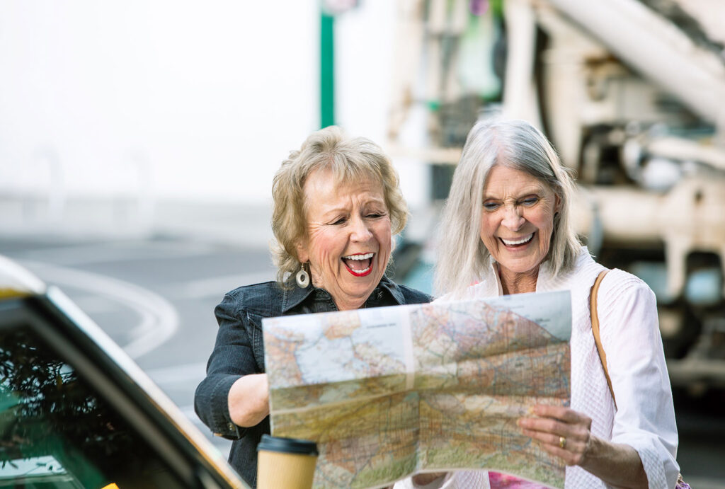 two women looking at a road map and smiling