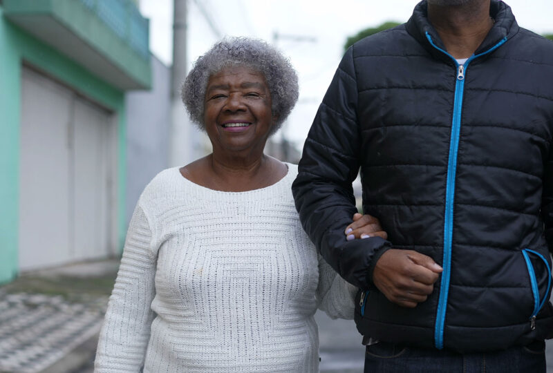 smiling senior woman walking arm in arm with man