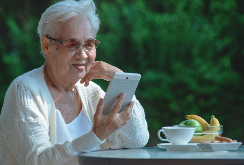 senior woman outside looking at smartphone