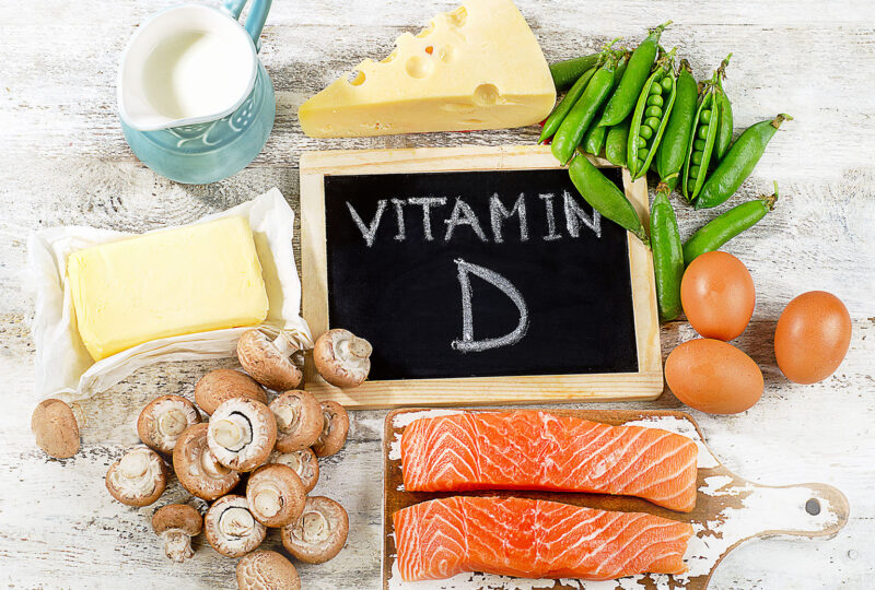 foods that contain vitamin d around a chalkboard with vitamin d written on it
