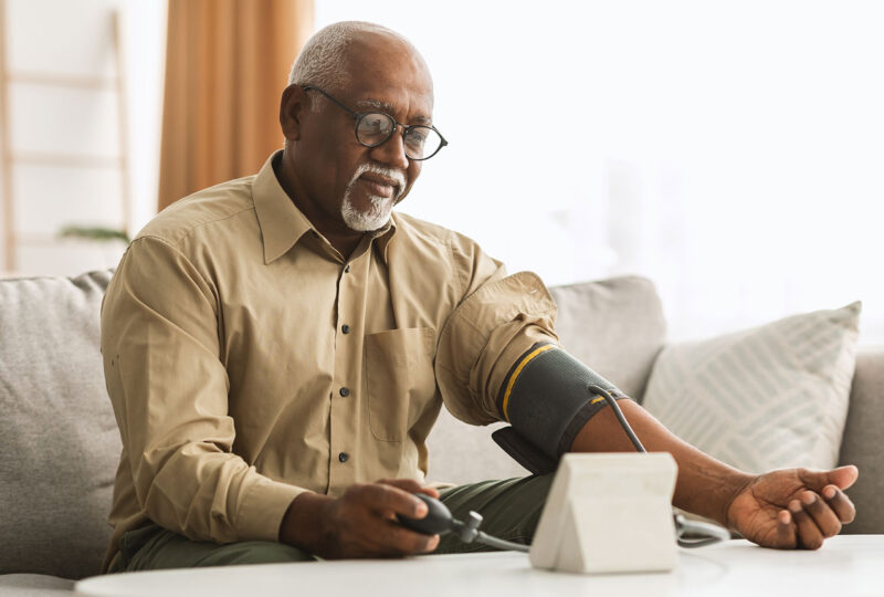 older man measuring blood pressure at home