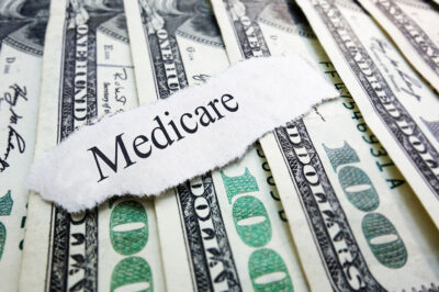 medicare typed on paper laying over 100-dollar bills