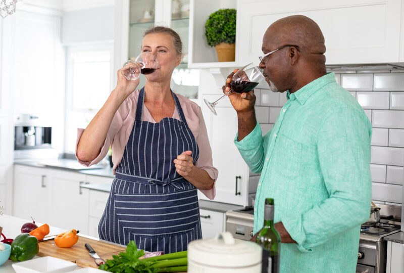 man and woman in a kitchen drinking wine