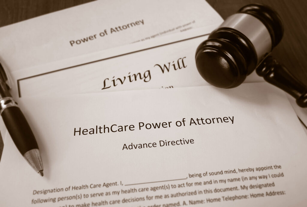 paperwork for health care poa and living will with a gavel and pen