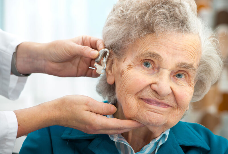 senior woman being fitted for hearing aids