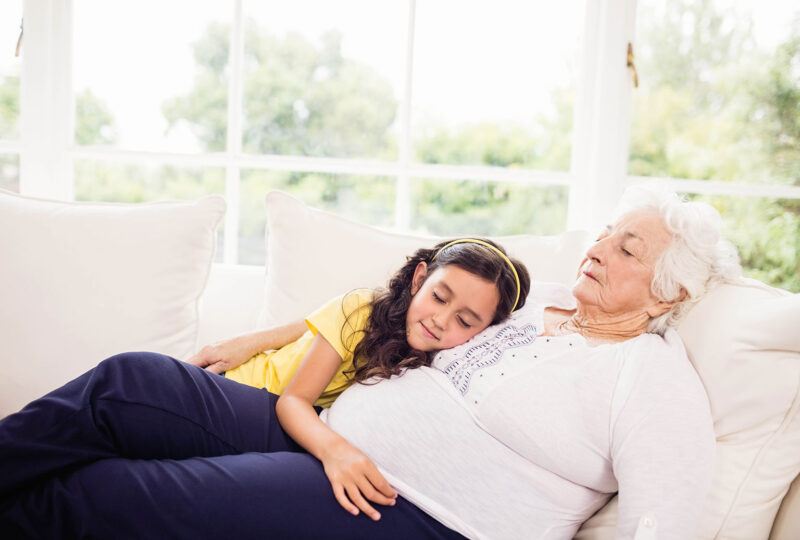 woman and granddaughter napping on couch