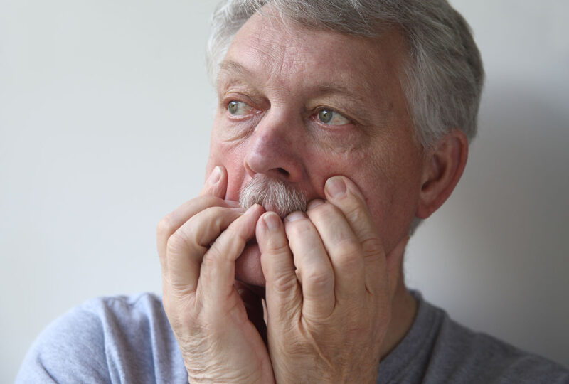 older man with hands on face, anxious, agitated