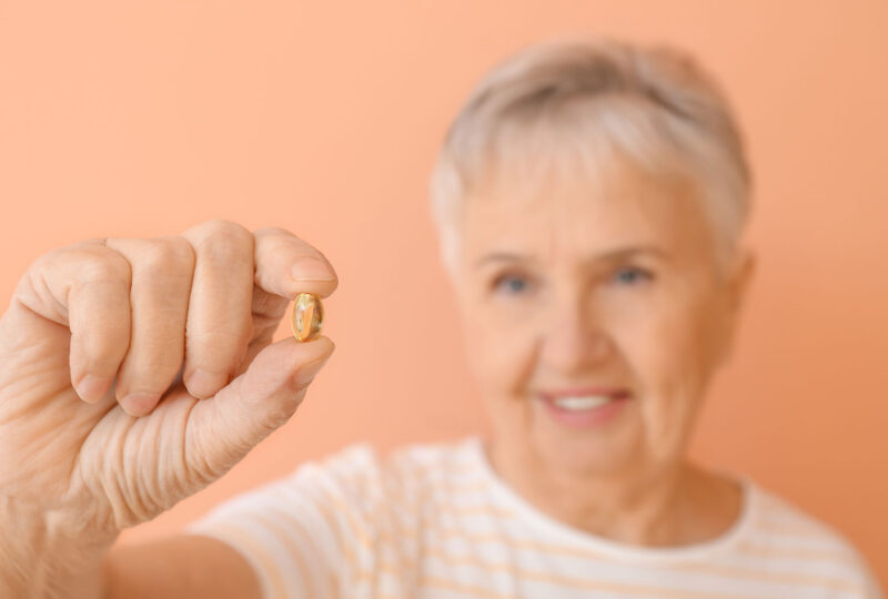 woman holding gel capsule supplement