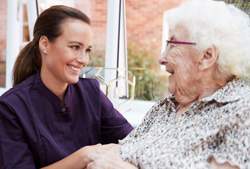 woman smiling at mom or grandma at assisted living