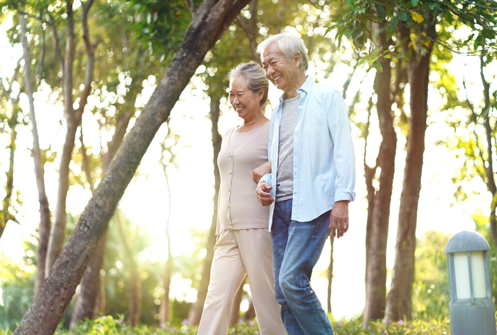 older couple walking outdoors arm in arm
