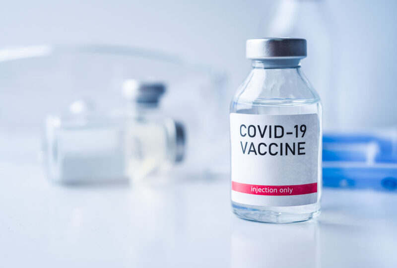 clear bottle with covid-19 vaccine sticker