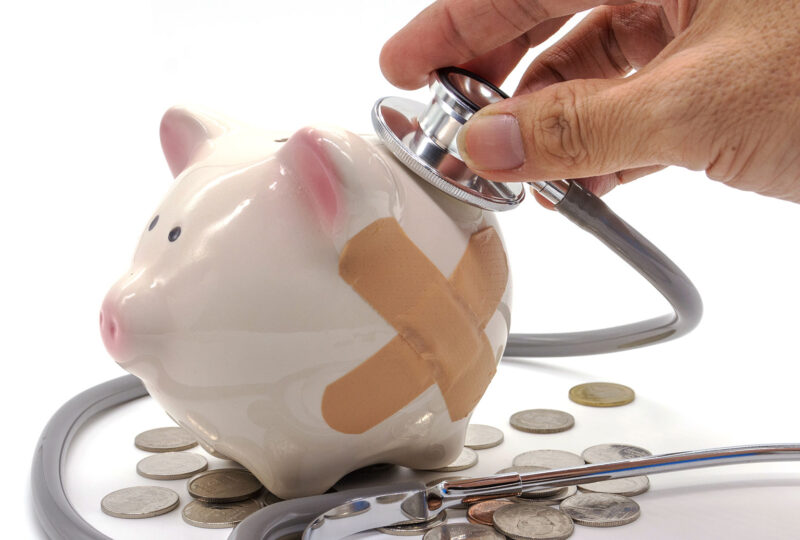 piggy bank with a bandaid and a stethoscope
