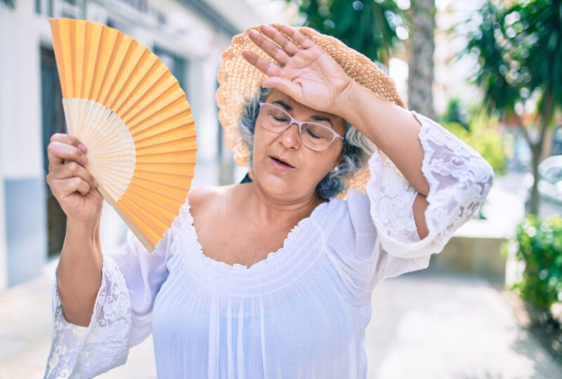 woman fanning herself in hot weather