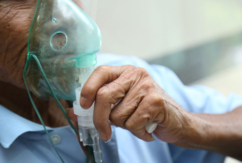 senior man holding oxygen mask to his face