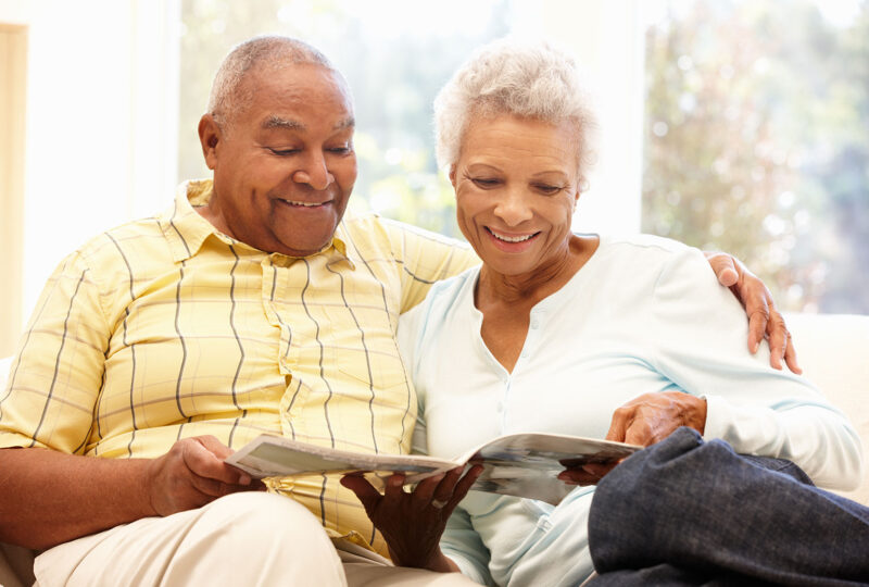 older couple sitting on the couch together reading