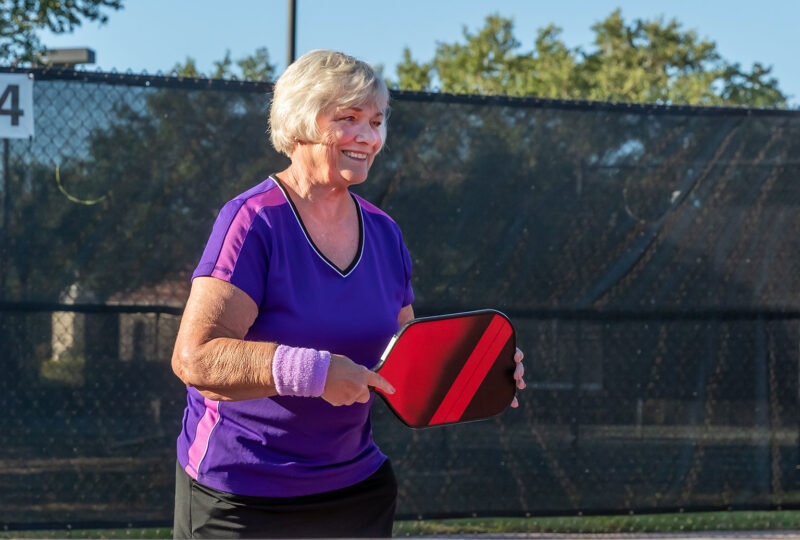woman standing with pickleball racquet