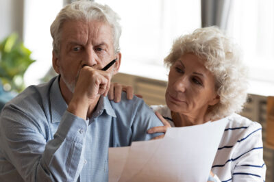 thoughtful older couple looking at paperwork