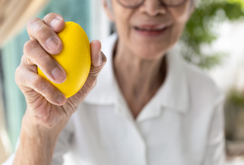 older woman holding a ball for hand grip strength exercises