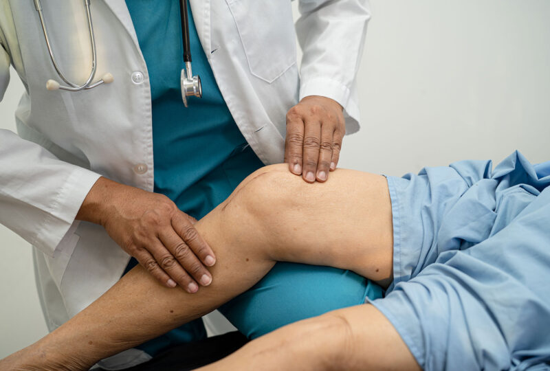a doctor checking a person's knee after surgery