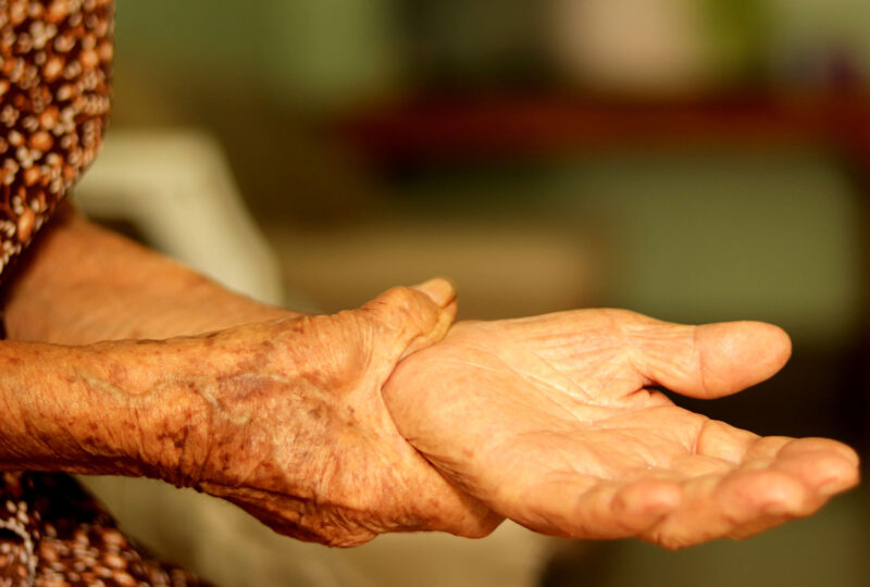senior grabbing wrist as if in pain from arthritis